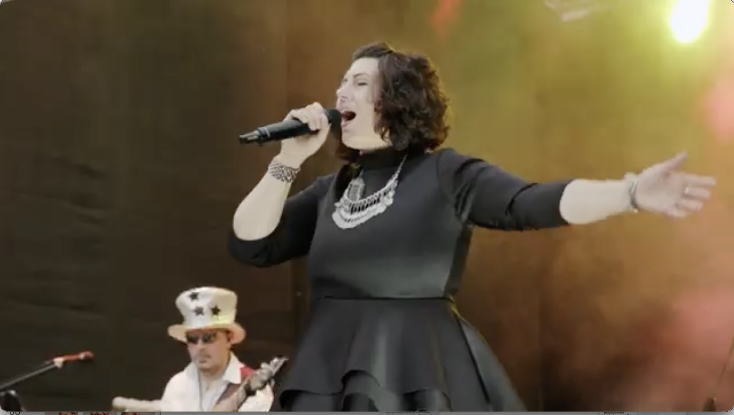 Claudia Erlenbusch singt mit ausgestrecktem Arm auf der Bühne